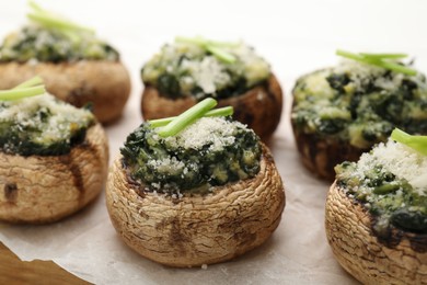 Photo of Tasty stuffed mushrooms served on white wooden table, closeup