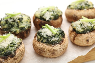 Photo of Tasty stuffed mushrooms served on white wooden table, closeup