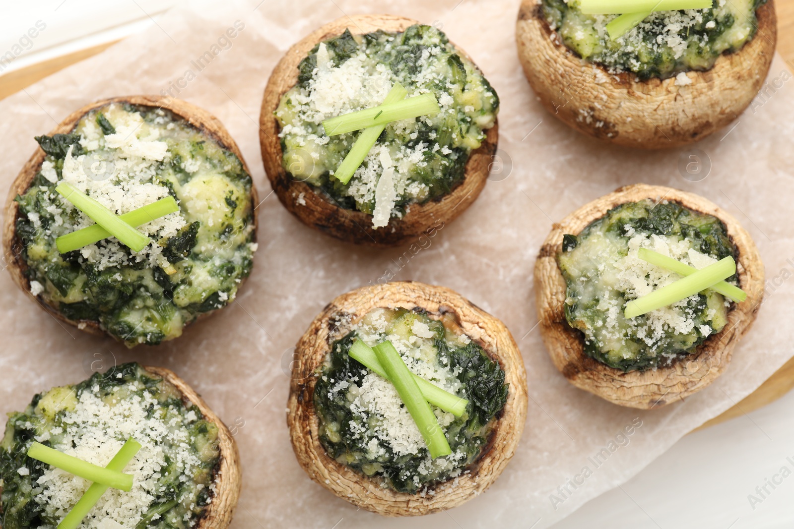 Photo of Tasty stuffed mushrooms served on white wooden table, top view