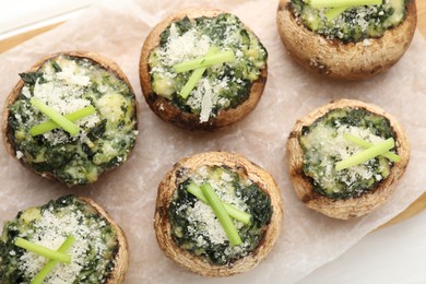 Photo of Tasty stuffed mushrooms served on white wooden table, top view