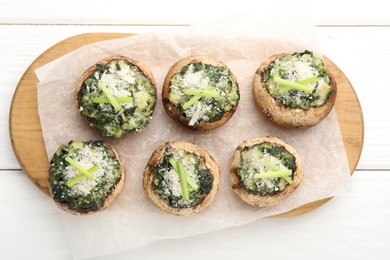 Photo of Tasty stuffed mushrooms served on white wooden table, top view