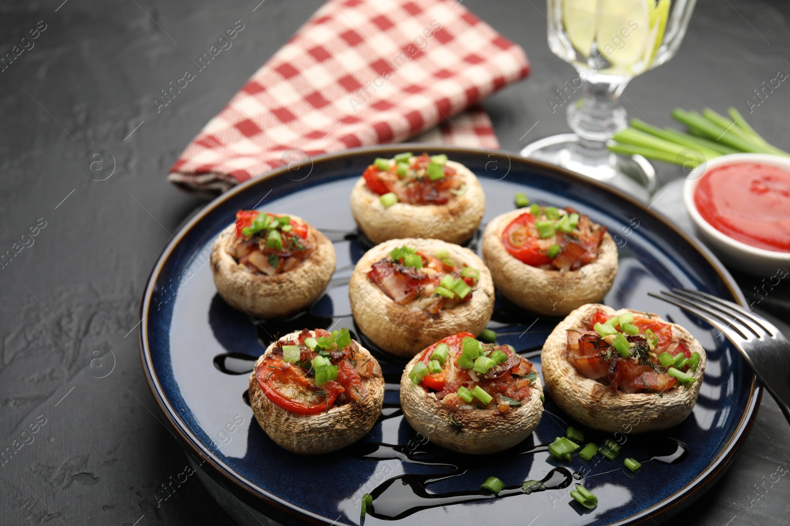 Tasty stuffed mushrooms served on black table, closeup Photo of Tasty stuffed mushrooms served on black table, closeup