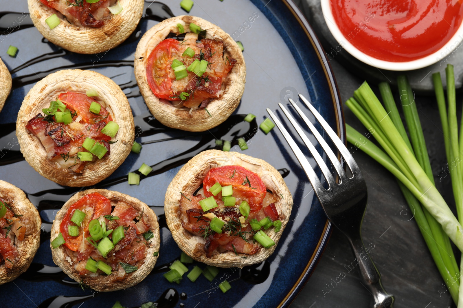 Tasty stuffed mushrooms served on black table, flat lay Photo of Tasty stuffed mushrooms served on black table, flat lay