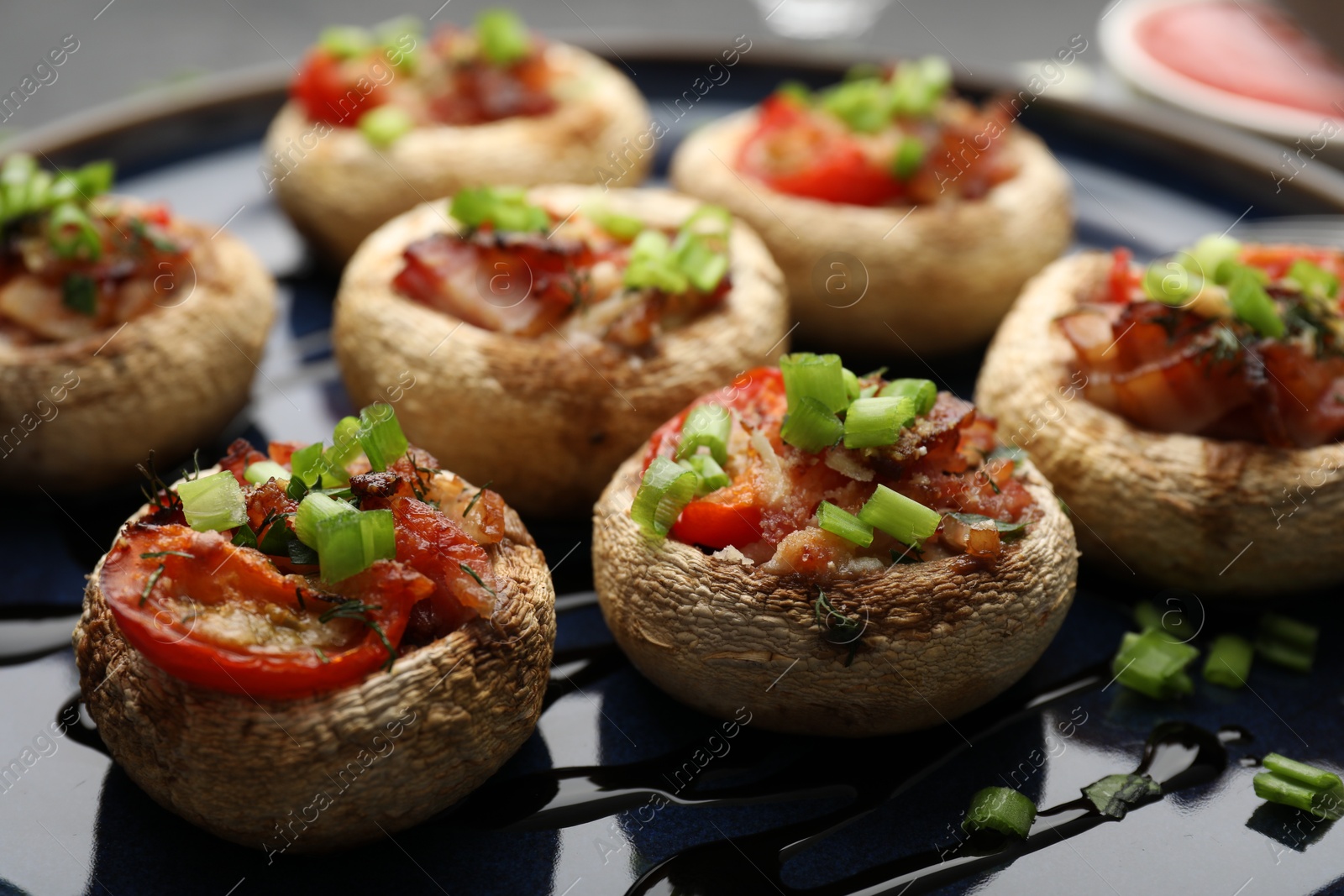Tasty stuffed mushrooms served on black table, closeup Photo of Tasty stuffed mushrooms served on black table, closeup