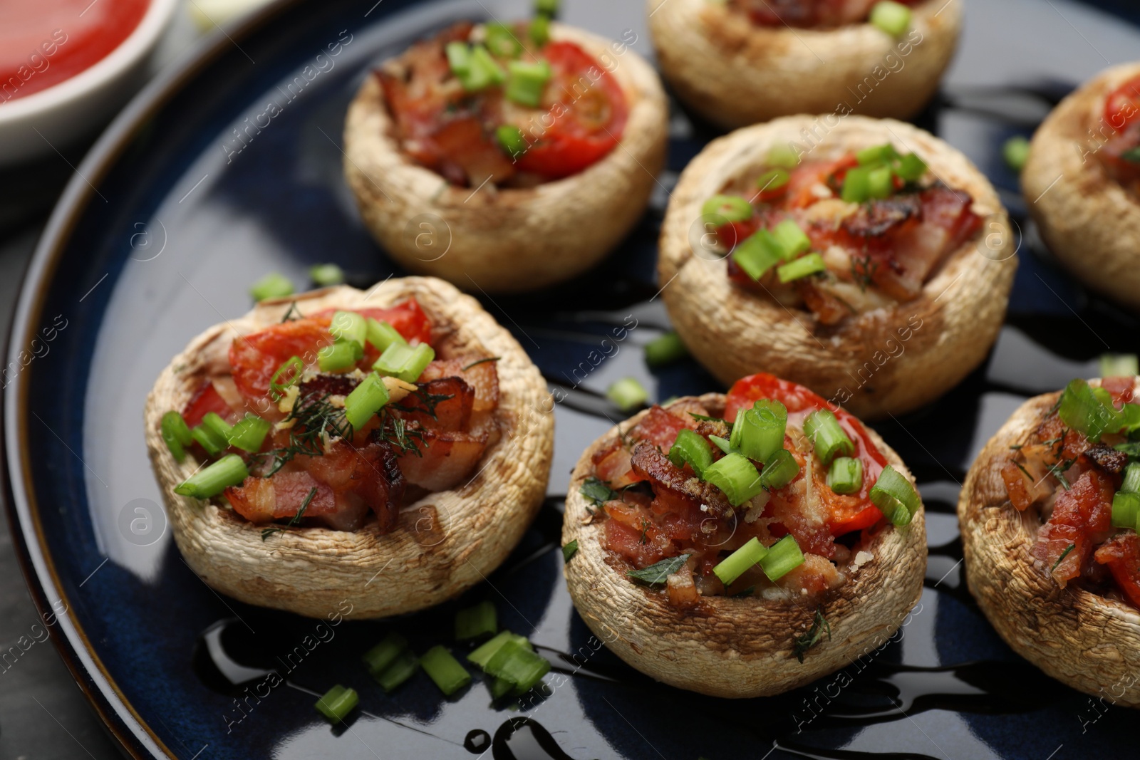 Tasty stuffed mushrooms served on black table, closeup Photo of Tasty stuffed mushrooms served on black table, closeup