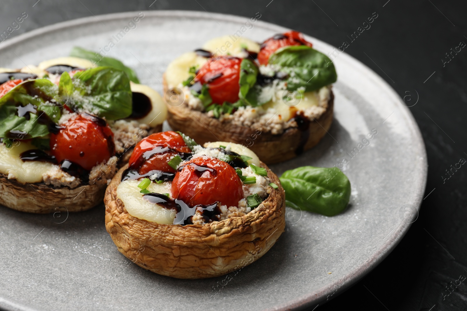 Tasty stuffed mushrooms served on black table, closeup Photo of Tasty stuffed mushrooms served on black table, closeup
