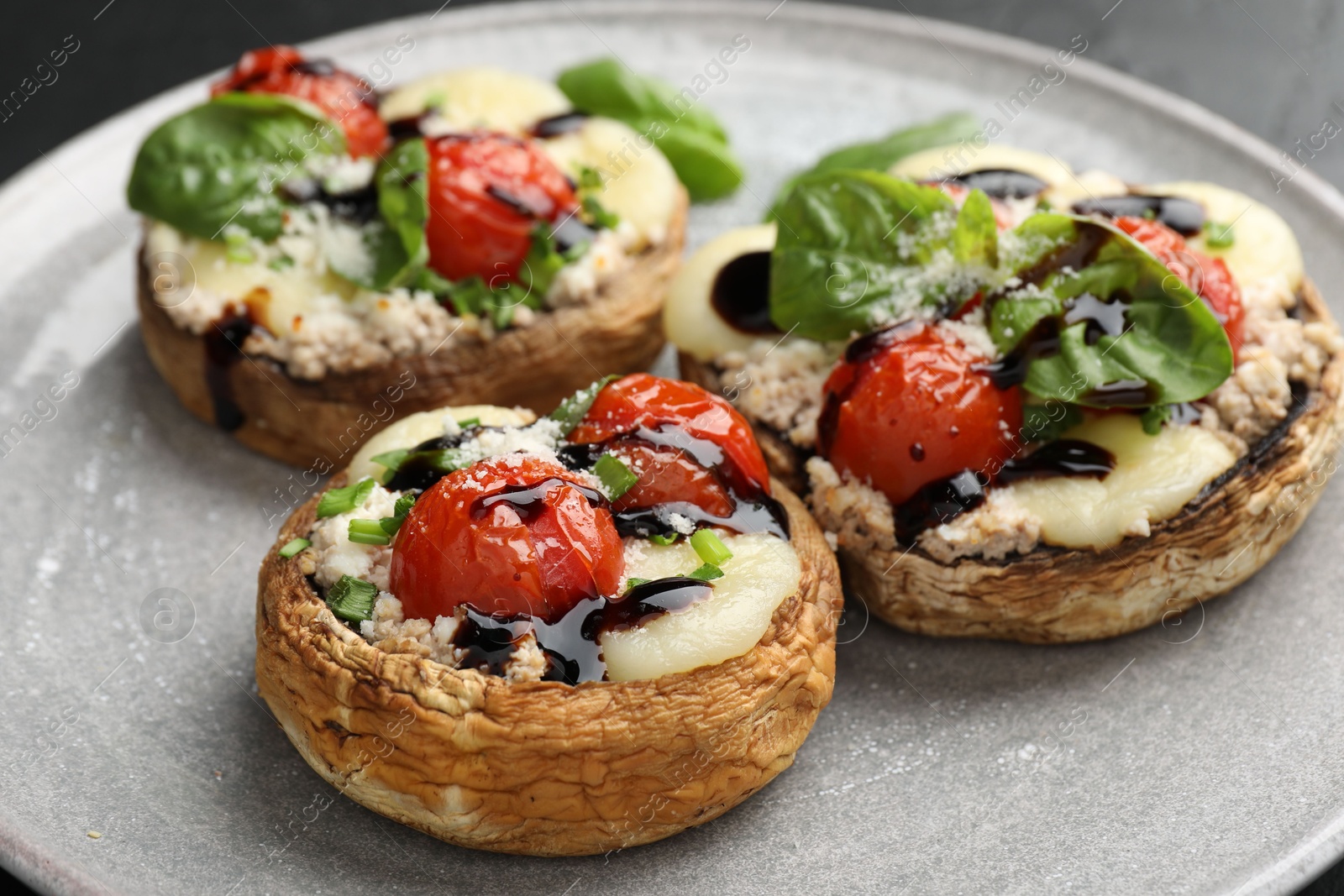 Tasty stuffed mushrooms served on black table, closeup Photo of Tasty stuffed mushrooms served on black table, closeup