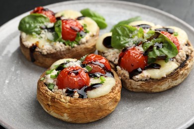 Photo of Tasty stuffed mushrooms served on black table, closeup