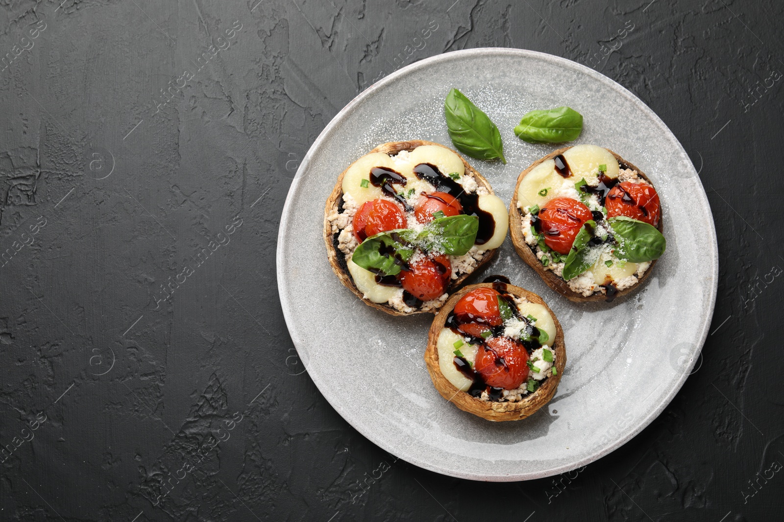 Tasty stuffed mushrooms served on black table, top view. Space for text Photo of Tasty stuffed mushrooms served on black table, top view. Space for text
