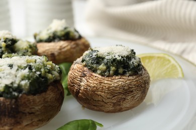 Photo of Tasty stuffed mushrooms served on table, closeup