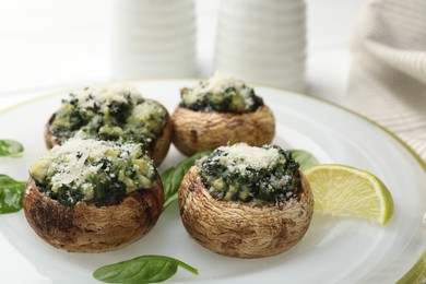 Photo of Tasty stuffed mushrooms served on white table, closeup
