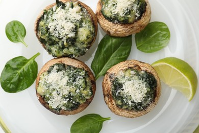 Photo of Tasty stuffed mushrooms on plate, top view