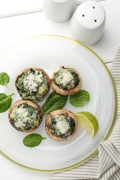 Photo of Tasty stuffed mushrooms served on white wooden table, top view