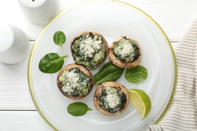 Photo of Tasty stuffed mushrooms served on white wooden table, top view