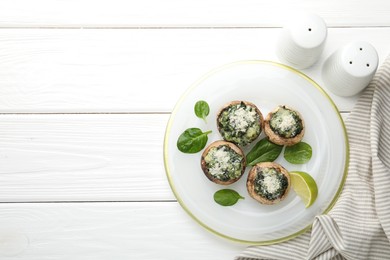 Photo of Tasty stuffed mushrooms served on white wooden table, top view. Space for text