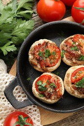 Photo of Tasty stuffed mushrooms served on wooden table, flat lay