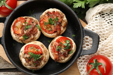 Photo of Tasty stuffed mushrooms served on wooden table, flat lay