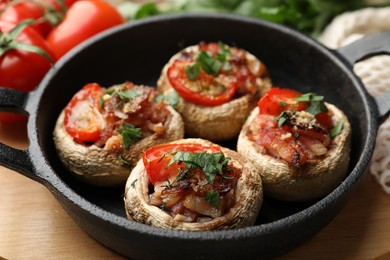 Photo of Tasty stuffed mushrooms served on wooden table, closeup