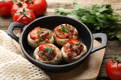 Photo of Tasty stuffed mushrooms served on wooden table, closeup
