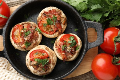 Photo of Tasty stuffed mushrooms served on wooden table, flat lay
