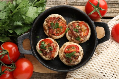Photo of Tasty stuffed mushrooms served on wooden table, flat lay