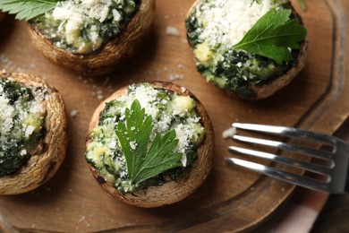 Photo of Tasty stuffed mushrooms served on wooden table, top view