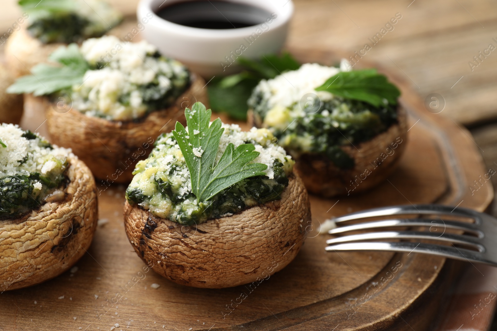 Tasty stuffed mushrooms served on wooden table, closeup Photo of Tasty stuffed mushrooms served on wooden table, closeup
