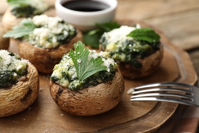 Photo of Tasty stuffed mushrooms served on wooden table, closeup