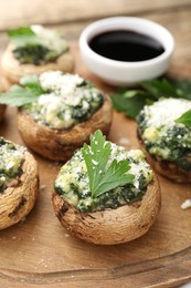 Photo of Tasty stuffed mushrooms served on wooden table, closeup
