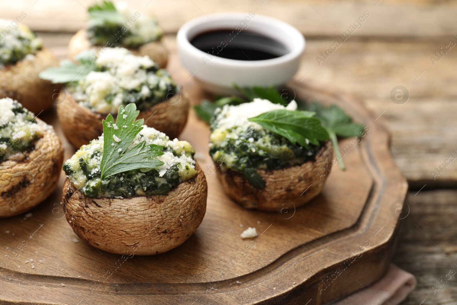 Tasty stuffed mushrooms served on wooden table, closeup Photo of Tasty stuffed mushrooms served on wooden table, closeup