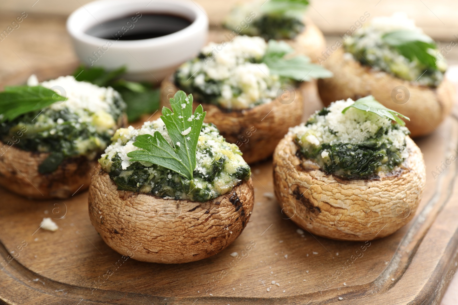 Tasty stuffed mushrooms served on wooden table, closeup Photo of Tasty stuffed mushrooms served on wooden table, closeup