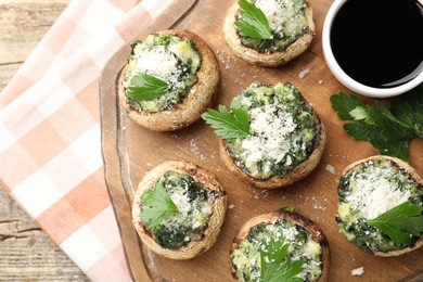 Photo of Tasty stuffed mushrooms served on wooden table, top view