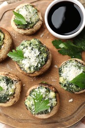 Photo of Tasty stuffed mushrooms served on wooden table, top view