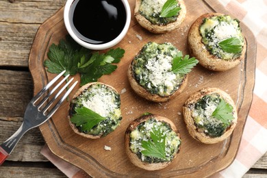 Photo of Tasty stuffed mushrooms served on wooden table, top view