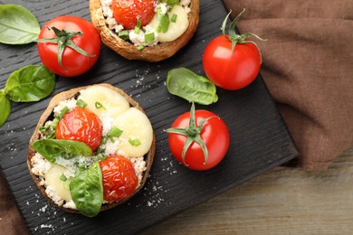 Photo of Tasty stuffed mushrooms served on wooden table, top view