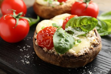 Photo of Tasty stuffed mushrooms served on wooden table, closeup