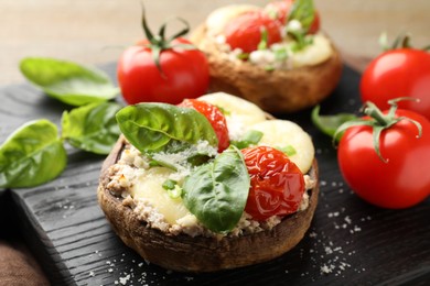 Photo of Tasty stuffed mushrooms served on wooden table, closeup