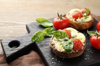 Photo of Tasty stuffed mushrooms served on wooden table, closeup