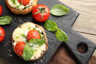 Photo of Tasty stuffed mushrooms served on wooden table, top view