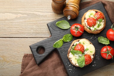 Photo of Tasty stuffed mushrooms served on wooden table, top view. Space for text