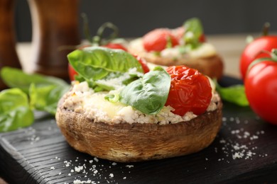 Photo of Tasty stuffed mushrooms served on wooden table, closeup