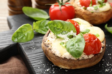 Photo of Tasty stuffed mushrooms served on wooden table, closeup