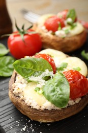 Photo of Tasty stuffed mushrooms served on wooden table, closeup