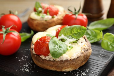 Photo of Tasty stuffed mushrooms served on wooden table, closeup