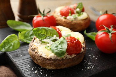 Photo of Tasty stuffed mushrooms served on wooden table, closeup