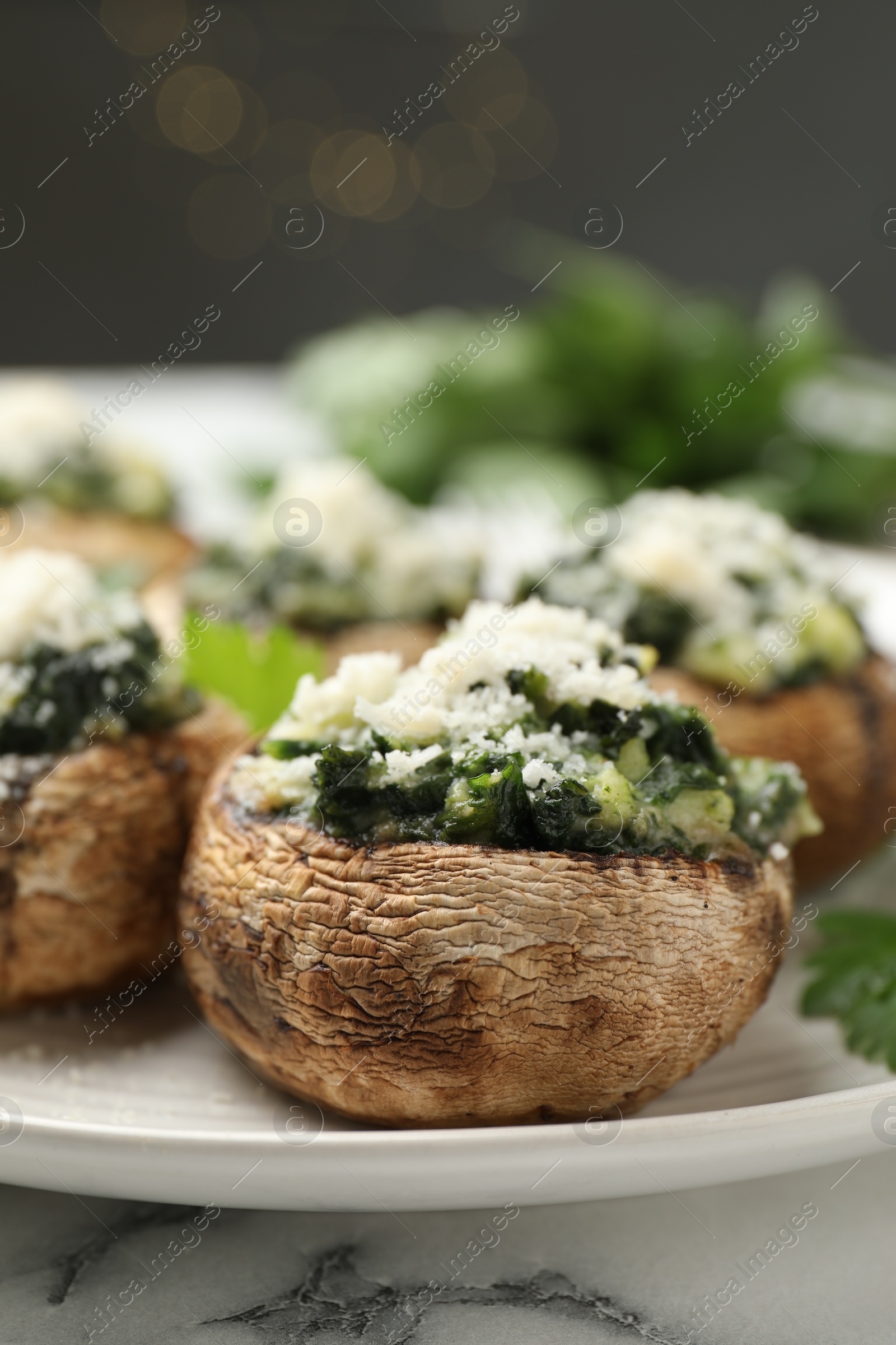 Tasty stuffed mushrooms served on white table against blurred background, closeup Photo of Tasty stuffed mushrooms served on white table against blurred background, closeup