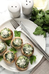 Photo of Tasty stuffed mushrooms served on white table, flat lay