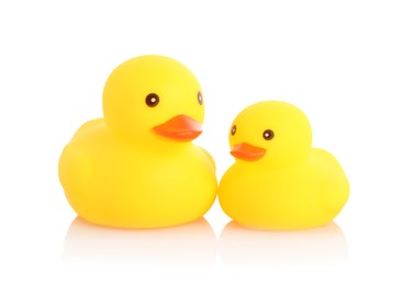 Photo of Cute rubber ducks on mirror surface against white background