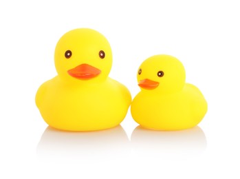 Photo of Cute rubber ducks on mirror surface against white background