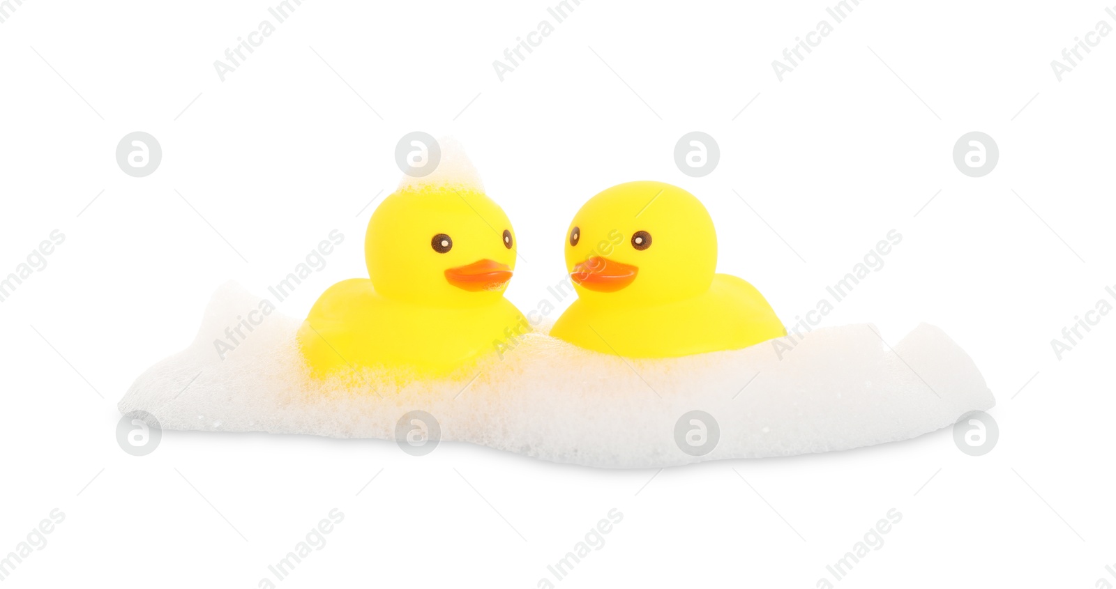 Cute rubber ducks and foam isolated on white Photo of Cute rubber ducks and foam isolated on white